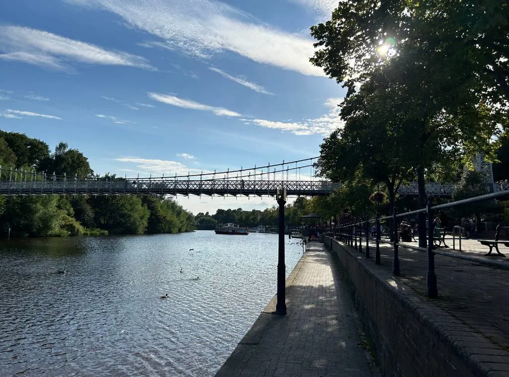 the river by the groves with a bridge spanning the river in the background