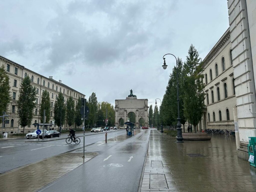 walking down a street with an arch in Munich