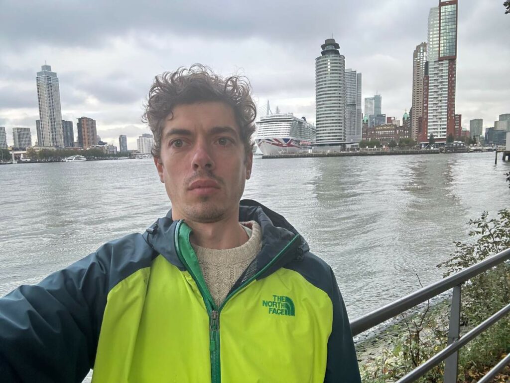 Tom in Rotterdam with the harbour and buildings behind him