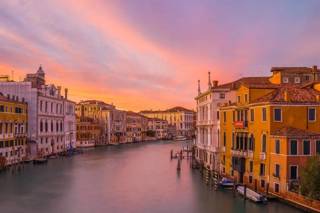 A canal in Venice with buildings either side right next to the water