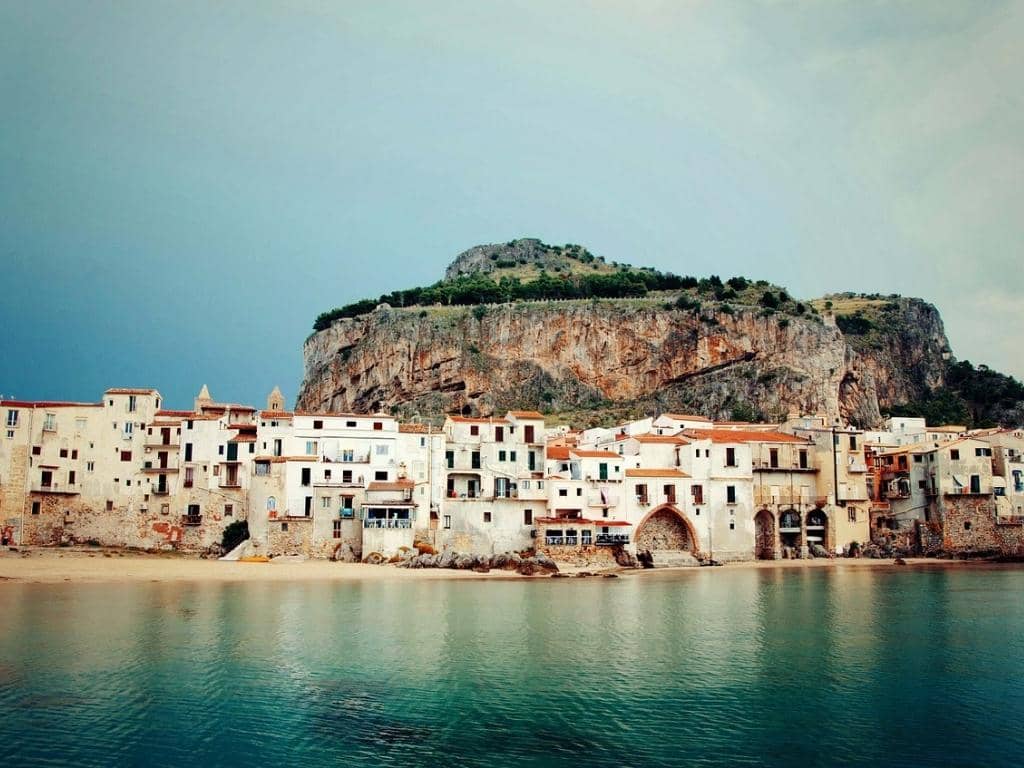 houses in front of the beach at Cefalù with a hill, La Rocca in the background