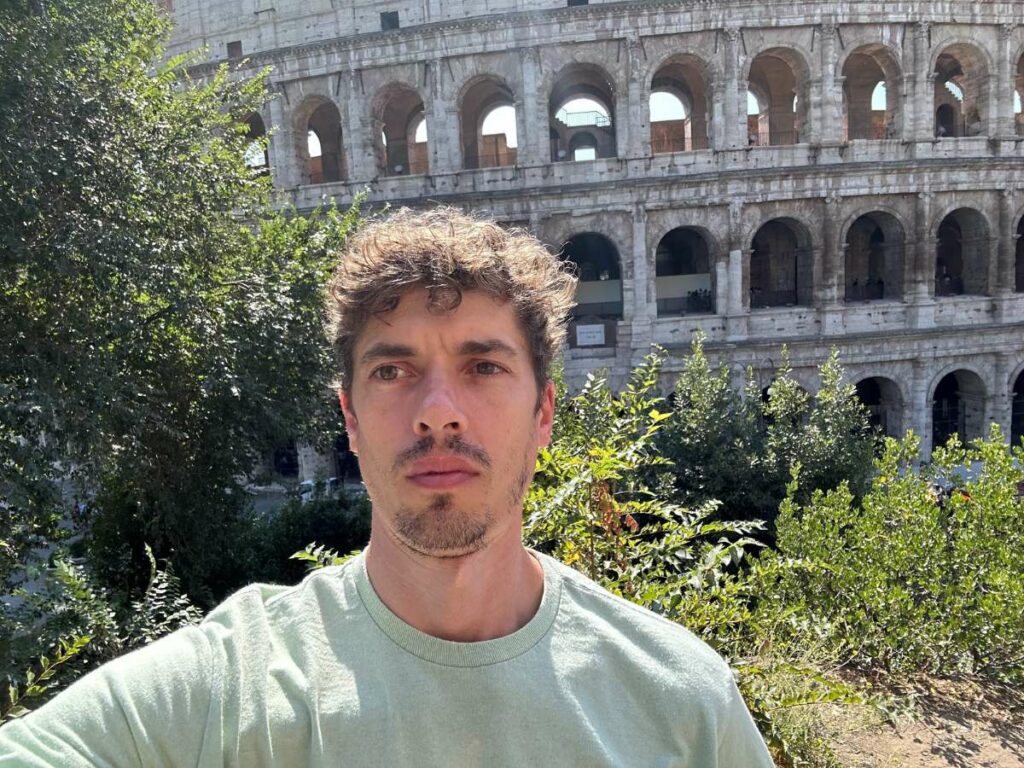 Tom in Rome with the Colosseum behind him