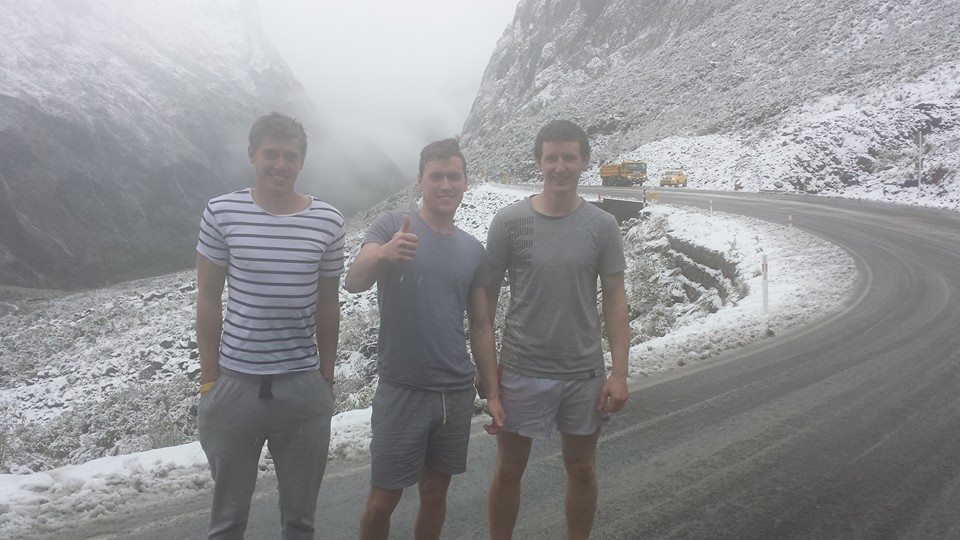 three people standing outside in the snow in t-shirts and shorts