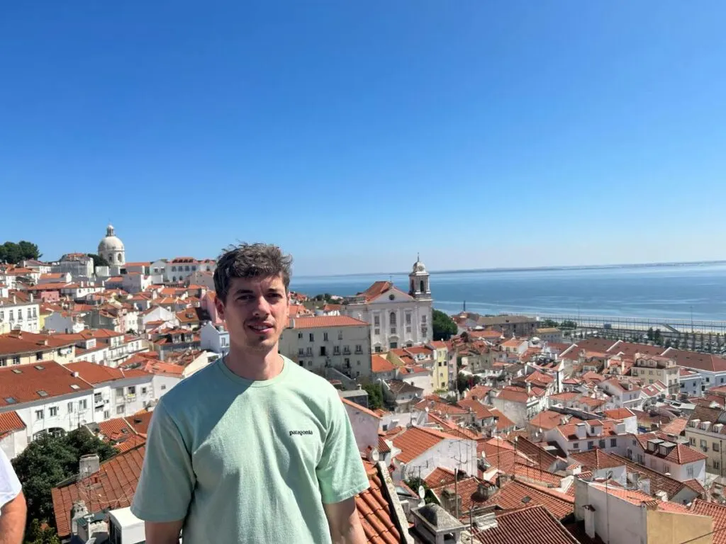 Me in Lisbon standing in front a backdrop of builidngs