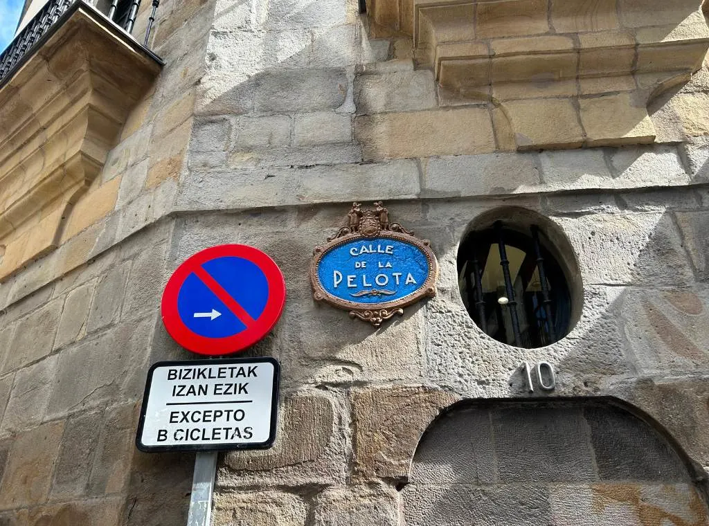 the street sign for calle de la pelota on the side of a wall