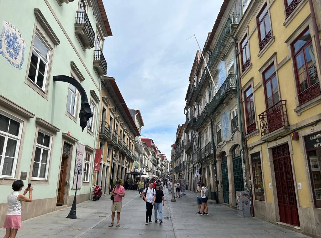walking down a street in porto with coloured houses on both sides