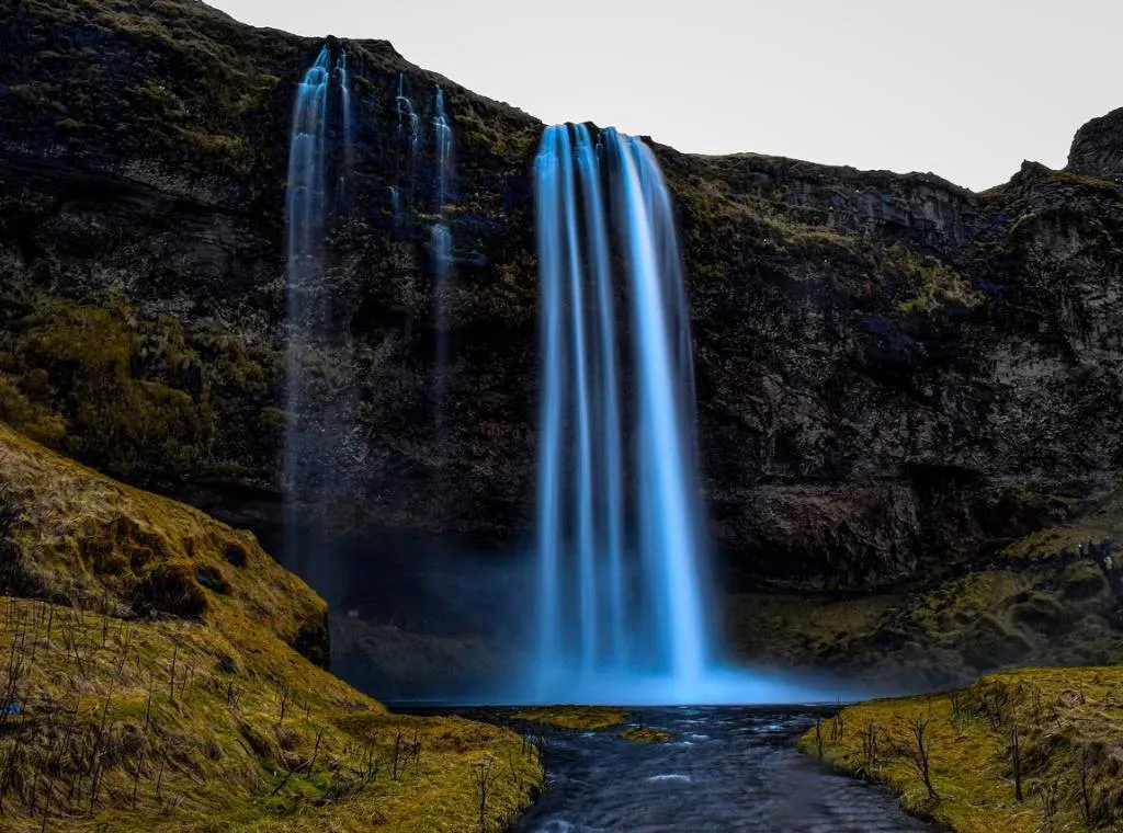 a waterfall falling into a large pool of water in Thingvellir National Park