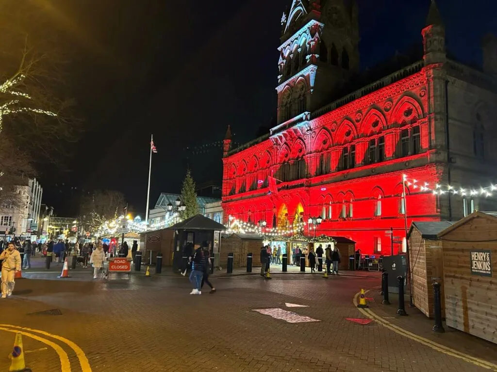 Christmas markets in Chester with the Town Hall illuminated in red