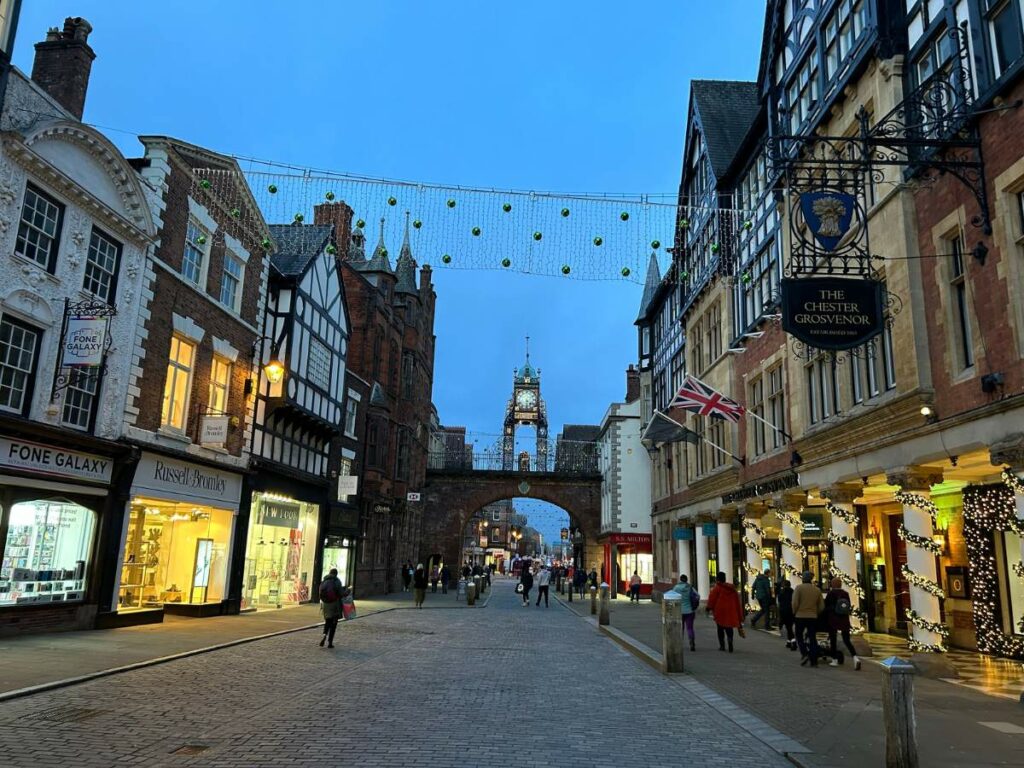 The Eastgate Clock at night with shops either side