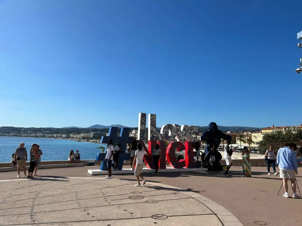 people standing in front of the I Love Nice sign