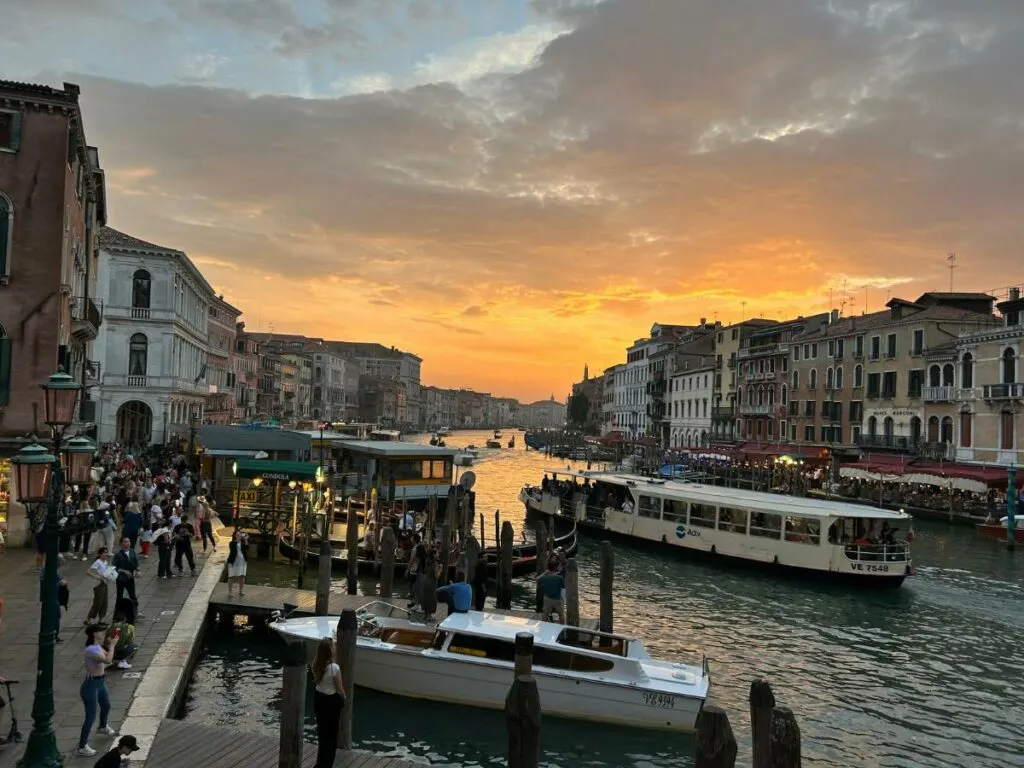 view of the Grand Canal in Venice from Rialto Bridge with the sun setting in the background