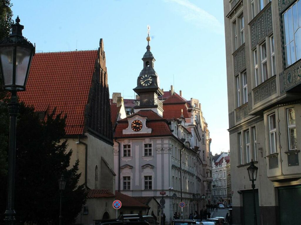 Jewish Town Hall in Prague with whit facade, orange roof and a clock tower